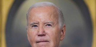 Man in suit looking thoughtful with blurred background.