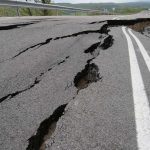Road damaged by significant cracks and fissures.