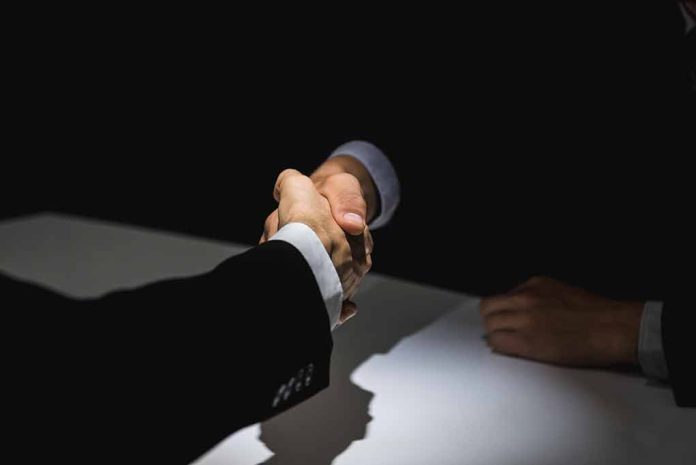 1091121377 featured image Two people in suits shaking hands.