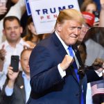 Man in suit standing at a rally event