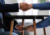 Handshake and exchange of money under the table.