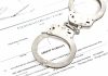 Handcuffs on top of arrest warrant document