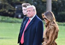 Three people walking outside on a grassy area