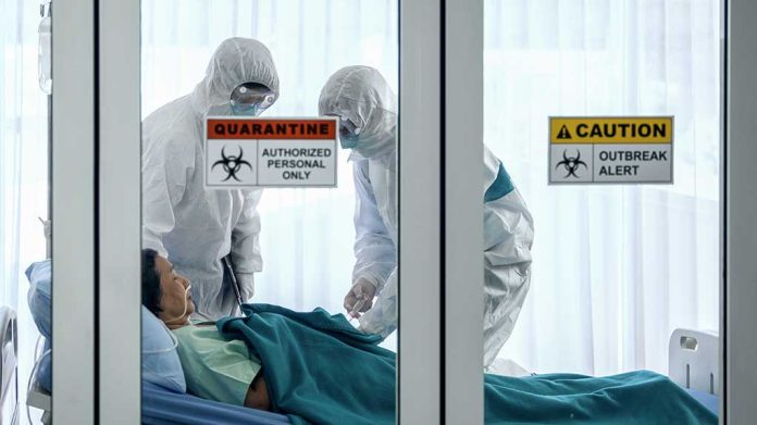 1647350797 featured image Healthcare workers in protective gear in quarantine room.