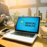 Laptop displaying "Mental Health" screen in an office.