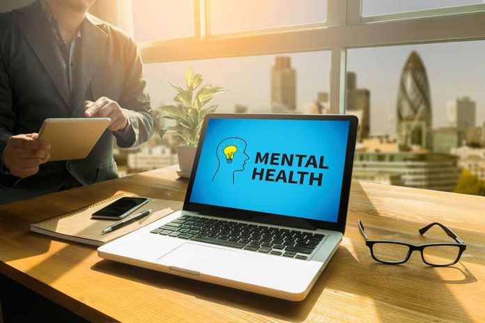 466292177 featured image Laptop displaying "Mental Health" screen in an office.