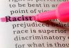 "Racist" highlighted in pink marker in a book.