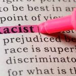 "Racist" highlighted in pink marker in a book.