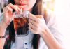Person drinking soda from a glass mug
