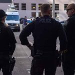 Three police officers standing on a city street