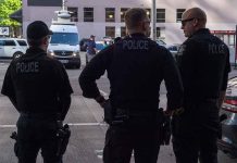 Three police officers standing on a city street
