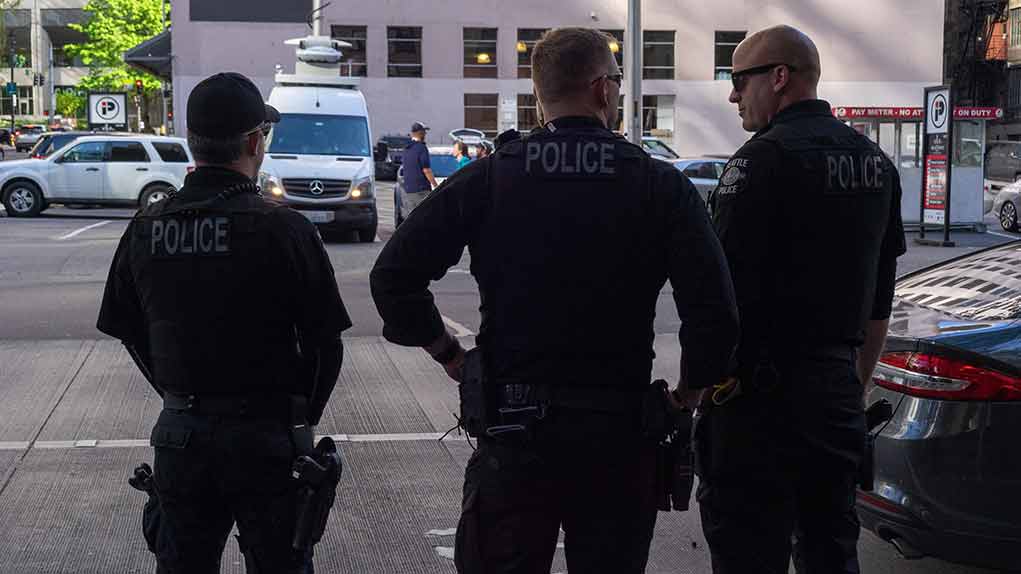 Three police officers standing on a city street