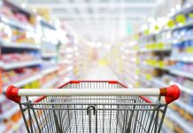 Shopping cart in aisle of grocery store