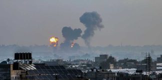Flames and smoke billowing over a cityscape