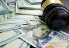 Gavel and hundred dollar bills on table
