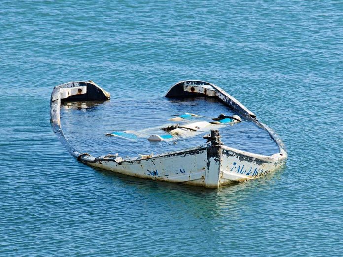 20081782 featured image Half-submerged weathered abandoned boat floating on calm water