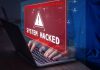 Warning sign System Hacked on laptop screen