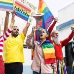 Diverse group at pride march with rainbow flags