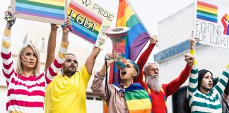 Diverse group at pride march with rainbow flags