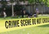 Yellow crime scene tape blocking grassy area