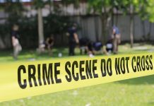 Yellow crime scene tape blocking grassy area