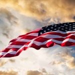 American flag waving against a cloudy sky