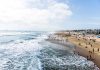 Crowded beach with waves and people enjoying sun