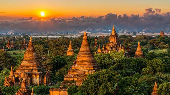 1449027275 Sunset over ancient temple complex with lush greenery.