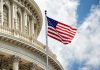 US flag in front of Capitol building dome