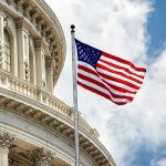 US flag in front of Capitol building dome