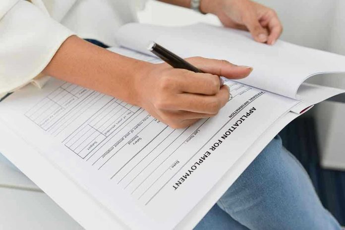 420099925 Person filling out job application form