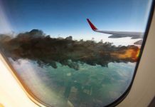 Airplane wing with engine on fire mid flight