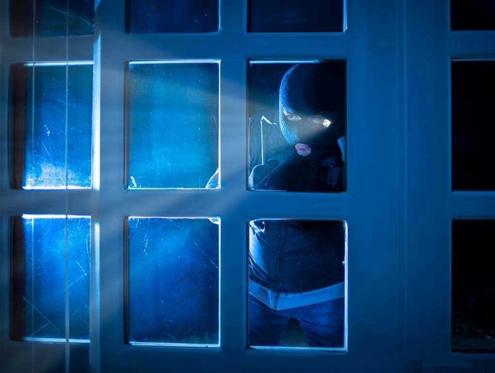 514808032 Masked figure peering through glass door at night