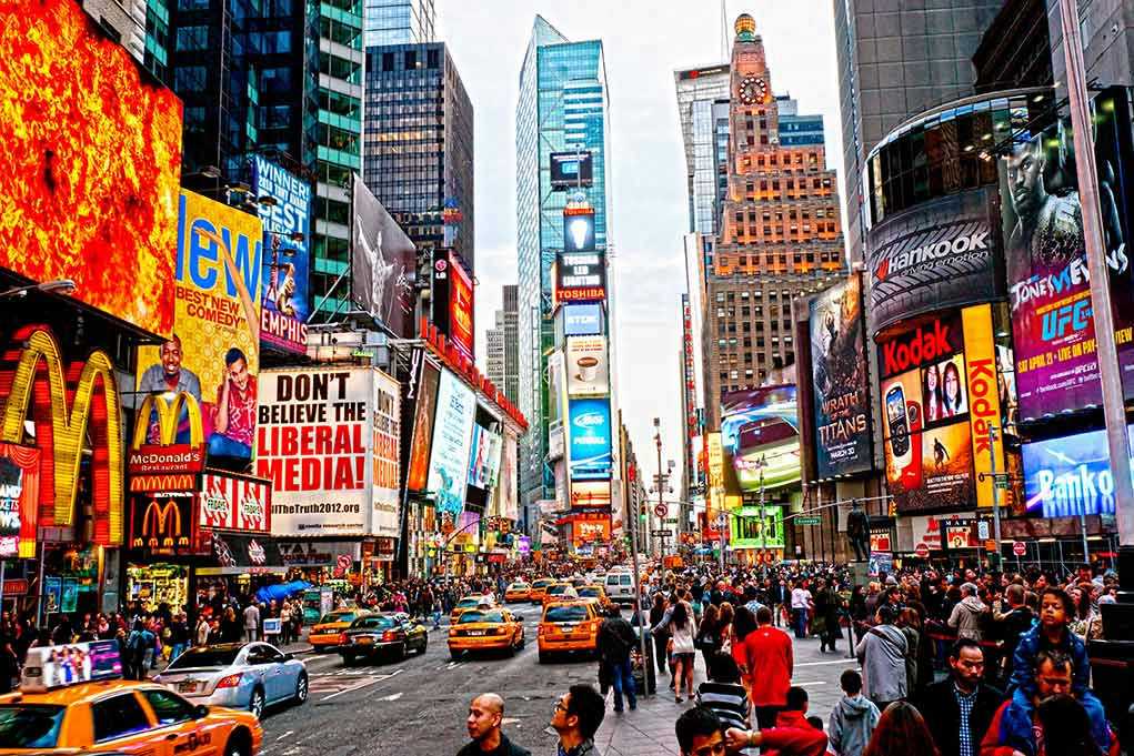 Times Square crowded with people and bright electronic advertisements