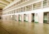 Interior view of a prison cell block with empty cells and security bars