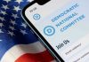 Phone displaying Democratic National Committee website over flag.