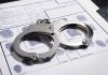 Handcuffs on fingerprint form with fingerprints visible.