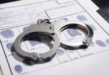 Handcuffs on fingerprint form with fingerprints visible.