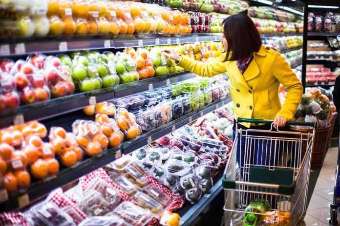 Woman in a yellow coat shopping for fruits in a supermarket