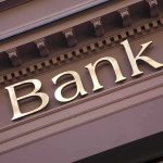 Close up of a bank sign with gold lettering