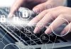 Hands typing with cybersecurity icons overlay
