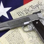 Gun on U.S. Constitution and flag