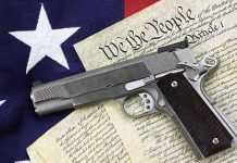 Gun on U.S. Constitution and flag
