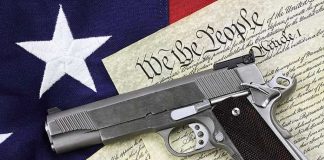 Gun on U.S. Constitution and flag