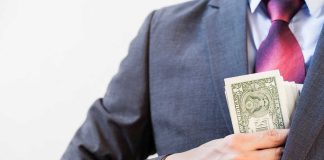 Person in suit putting money in jacket pocket
