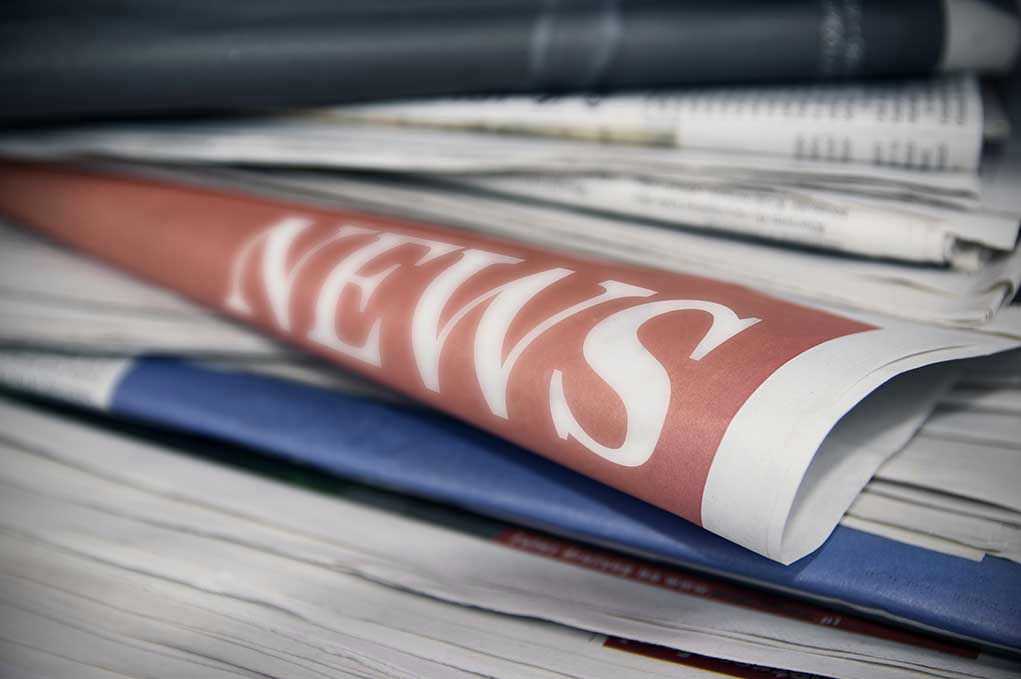 Stack of newspapers with NEWS headline visible