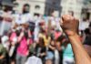 Lefty Trump Fan EXPOSES Anti-Trump Protest Chaos Raised fist in front of a crowd