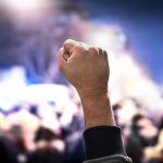 Violent Crackdown Sparks Global Outrage Raised fist in a crowd at night