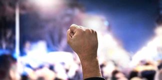 Raised fist in a crowd at night