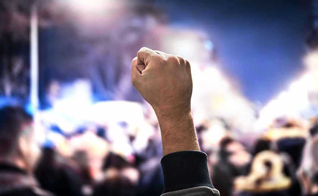 Raised fist in a crowd at night